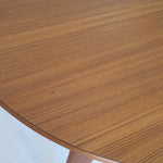 Table à manger ronde extensible vintage en teck miel, pieds fuseau, deux rallonges jusqu'à douze couverts, style scandinave fabrication française années 60