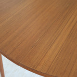Table à manger ronde extensible vintage en teck miel, pieds fuseau, deux rallonges jusqu'à douze couverts, style scandinave fabrication française années 60