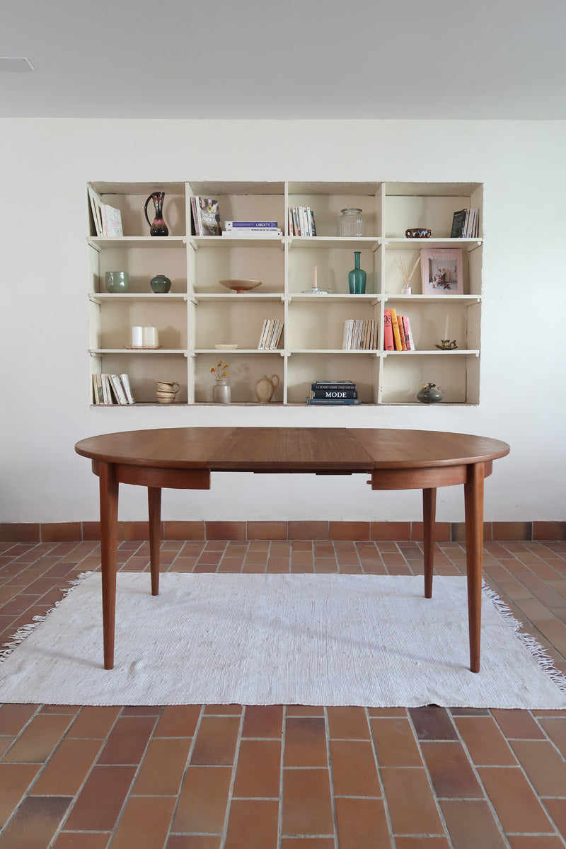 Table à manger ronde extensible vintage en teck miel, pieds fuseau, deux rallonges jusqu'à douze couverts, style scandinave fabrication française années 60