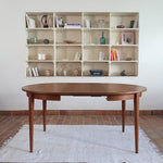 Table à manger ronde extensible vintage en teck miel, pieds fuseau, deux rallonges jusqu'à douze couverts, style scandinave fabrication française années 60