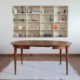 Table à manger ronde extensible vintage en teck miel, pieds fuseau, deux rallonges jusqu'à douze couverts, style scandinave fabrication française années 60