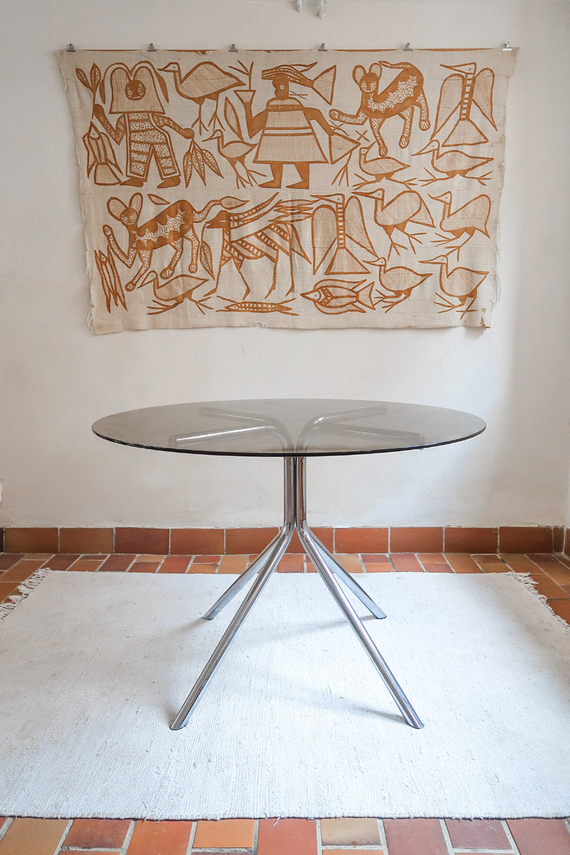 Table ronde années 70 avec plateau en verre fumé et piètement chromé sculptural à quatre branches.