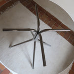 Table ronde années 70 avec plateau en verre fumé et piètement chromé sculptural à quatre branches.