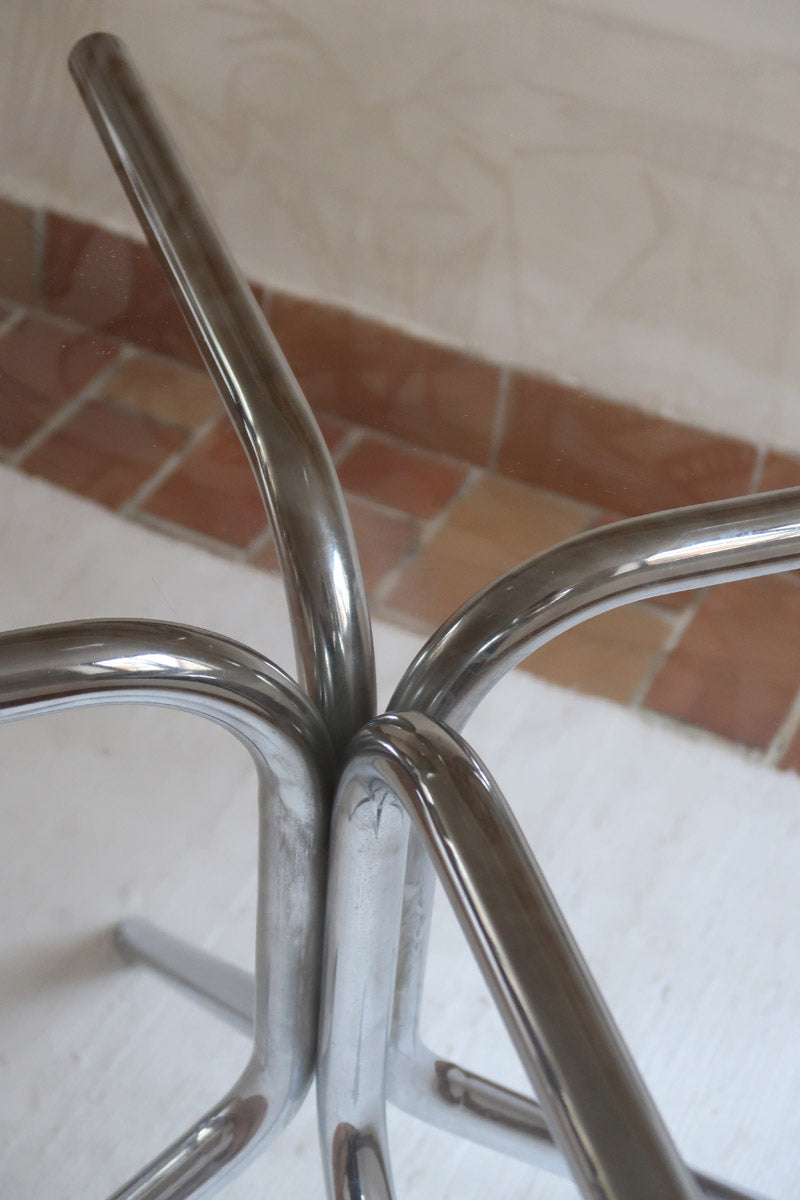 Table ronde années 70 avec plateau en verre fumé et piètement chromé sculptural à quatre branches.
