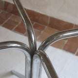 Table ronde années 70 avec plateau en verre fumé et piètement chromé sculptural à quatre branches.