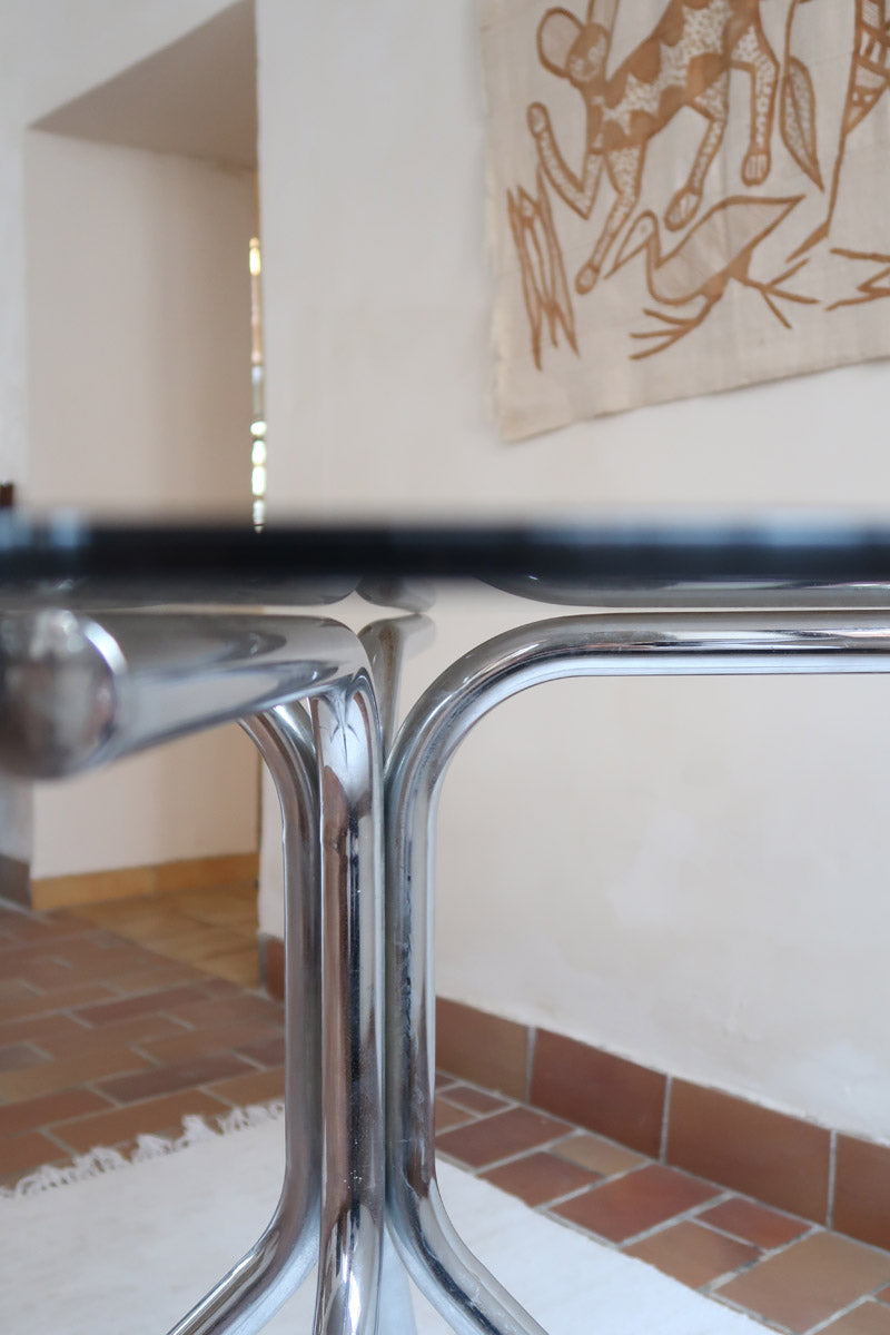 Table ronde années 70 avec plateau en verre fumé et piètement chromé sculptural à quatre branches.