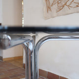 Table ronde années 70 avec plateau en verre fumé et piètement chromé sculptural à quatre branches.